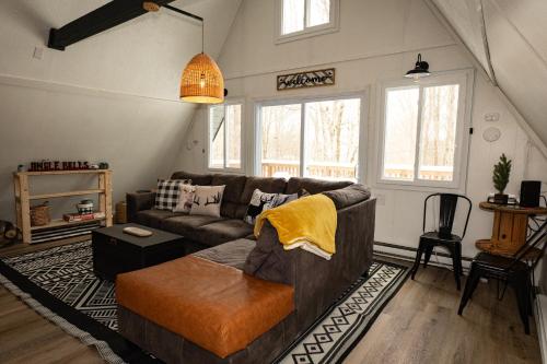 una sala de estar con un sofá y una mesa en Rustic Retreat, en Blakeslee