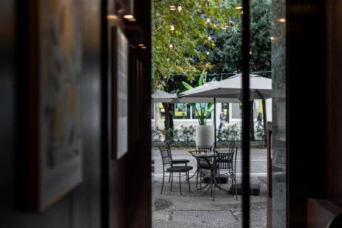 an outside view of a table and chairs with an umbrella at Palazzo Roma- Luxury Leading Hotels in Tirana