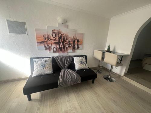 a living room with a couch and a picture of elephants at Serenity Apartment in Funchal