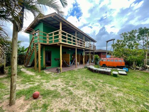 a house with an orange van parked in front of it at Jardins do Rosa - Hospedagem e Entretenimento in Imbituba