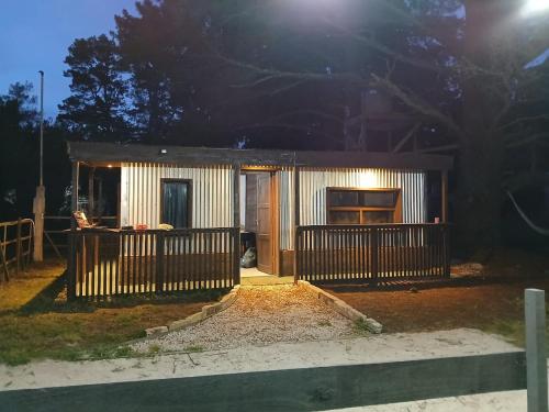 Cabaña lumar في San Eduardo del Mar: منزل صغير أمامه سور