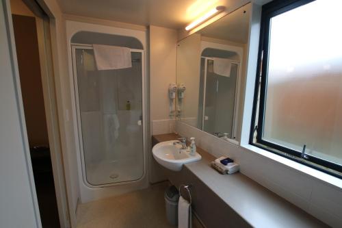 a bathroom with a sink and a shower at Bella Vista Motel Kaikoura in Kaikoura