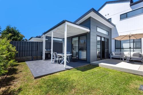 a house with a patio with a table and chairs at Saoire - Pet Friendly - 5 Mins Walk to Beach in Culburra Beach