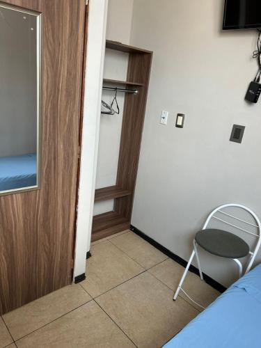 a room with a bed and a chair next to a door at hostal confort Iztapalapa hospedaje económico y cómodo en cdmx in Mexico City