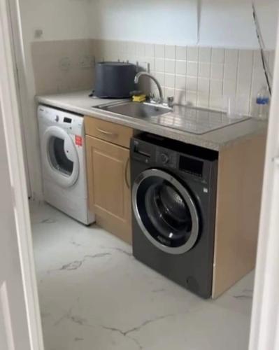 a kitchen with a sink and a washing machine at 4 Bed Detached Home Perfect for Families & Groups in Glasgow