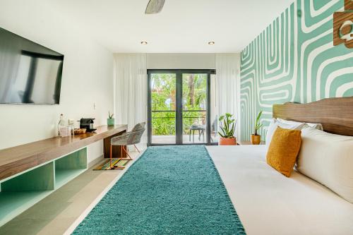 a bedroom with a bed with a blue rug at Mayan Monkey Isla Mujeres - Social Hotel in Isla Mujeres