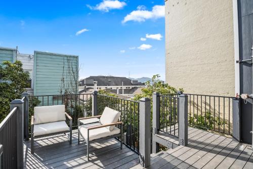 a balcony with two chairs and a fence at Kasa The Addison San Francisco in San Francisco