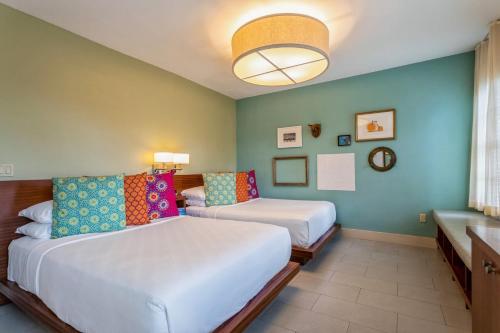 a hotel room with two beds and a window at Kasa El Paseo Miami Beach in Miami Beach