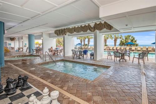 a pool with a chess board and tables and chairs at A Piece of Paradise, Newly Renovated in Myrtle Beach