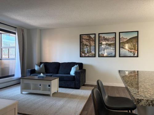a living room with a couch and a table at Chic & Spacious 2BR at Stampede with Parking, AC in Calgary