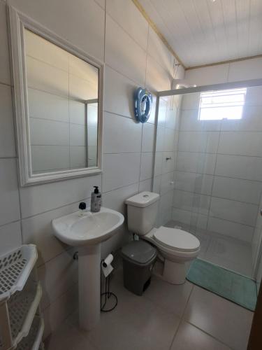 Un baño con inodoro, lavabo y ducha. en Casa com Piscina em Itapirubá, en Imbituba