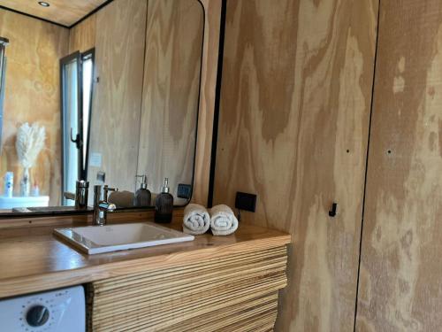 un bagno con lavandino e specchio di elcontainerdeacantilados a Mar del Plata