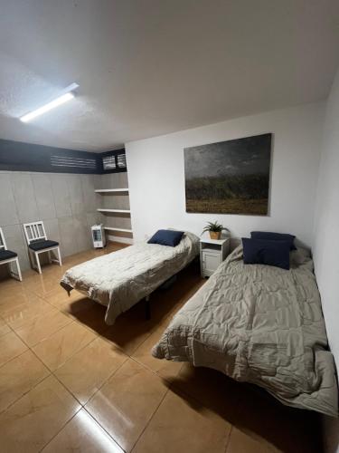 a bedroom with two beds and a painting on the wall at Oasis de paz junto al mar in Maspalomas