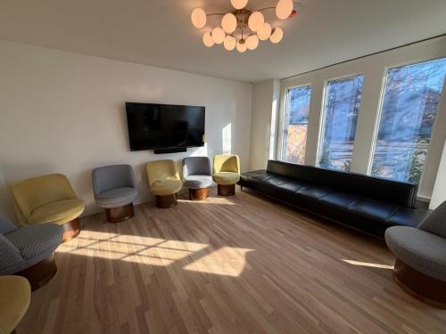 a living room with chairs and a flat screen tv at The Einstein Room in Boise