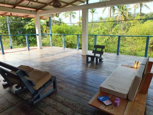 a porch with a bed and a table and chairs at Lunaria Pacífico in El Valle