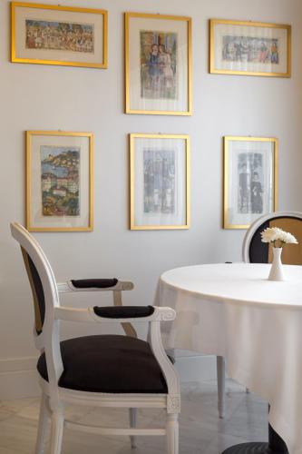 a white table and chairs in a room with pictures at Anaktorikon Boutique Hotel in Tripolis