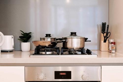 2 ollas y sartenes en una cocina en 1Br City View apt near SthnCrs Wifi Pool Gym, en Melbourne