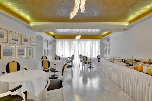 a restaurant with white tables and chairs and a bar at Anaktorikon Boutique Hotel in Tripoli