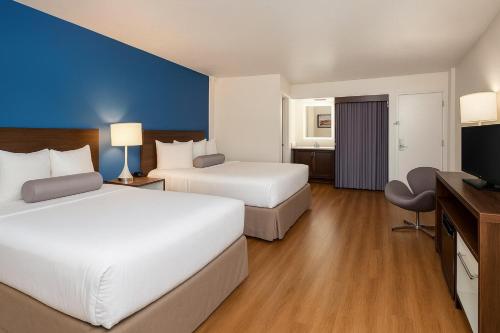 a hotel room with two beds and a flat screen tv at Spokane Boutique Hotel in Spokane