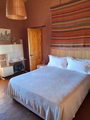 a bedroom with a large bed with a wooden headboard at La Chakana in Cachí
