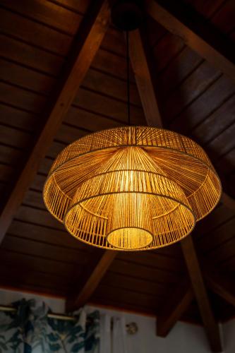 a wicker light fixture hanging from a wooden ceiling at Casa Naya in Pointe-Noire
