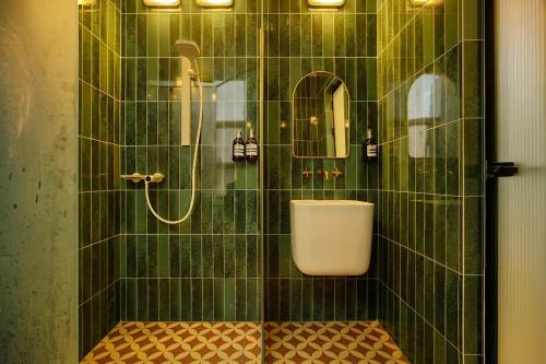 a green tiled bathroom with a shower with a toilet at Still apartment in Guangzhou