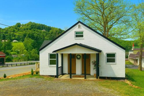 una piccola casa bianca sul ciglio di una strada di Blue Ridge Main St Mountain View Cottage a Sparta