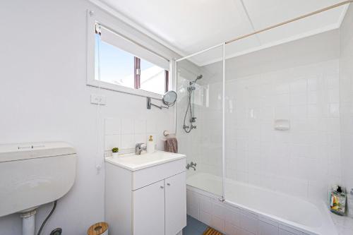 a white bathroom with a sink and a shower at Love You Moore in Guilderton