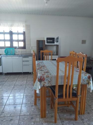 a kitchen with a table and chairs and a kitchen with a table and a table at Apto com terraço coberto in Arroio do Sal