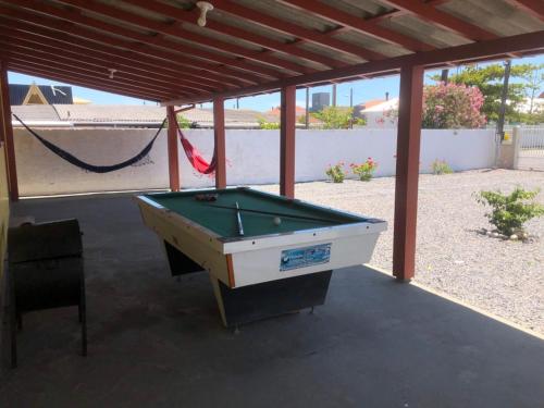 A melhor Casa na praia para temporada في باليوسا: جلسة طاولة بلياردو تحت الجناح