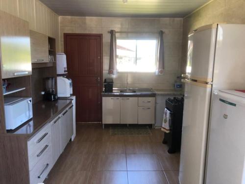 A melhor Casa na praia para temporada في باليوسا: مطبخ مع ثلاجة ومغسلة