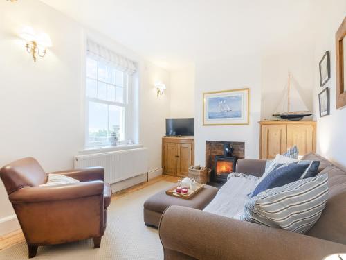 ein Wohnzimmer mit Sofa und Kamin in der Unterkunft Baytree Cottage in Fareham