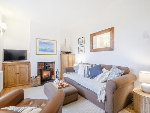 ein Wohnzimmer mit Sofa und Kamin in der Unterkunft Baytree Cottage in Fareham