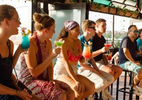a group of people sitting at a bar with drinks at Mayan Monkey Cancun - Social Hotel in Cancún