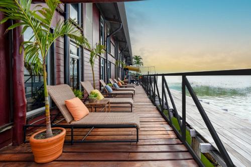 a row of chairs sitting on a dock with the water at Mayan Monkey Cancun - Social Hotel in Cancún