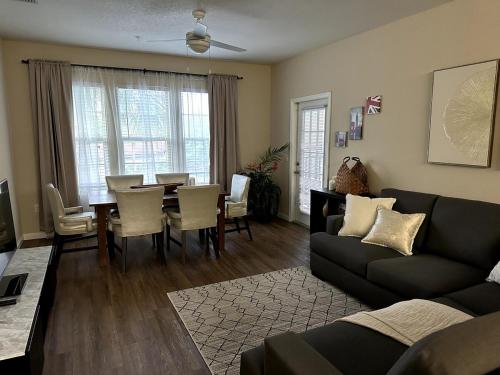 a living room with a couch and a dining room table at Orlando Bliss Near Disney in Orlando