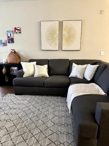 a living room with a black couch and a rug at Orlando Bliss Near Disney in Orlando