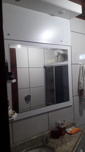 a bathroom with a mirror and a sink at Chácara mobiliada próximo Criciúma Br101 in Araranguá
