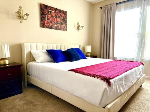 a bedroom with a large bed with blue and purple pillows at Orlando Bliss Near Disney in Orlando