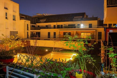 een appartementencomplex met een tuin ervoor bij Appartement Luxe - Smart Netflix & Alexa - 10 min La Défense 5 Guests 5 Beds in Bezons