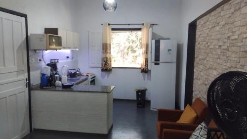 a small kitchen with a counter and a window at Vila mar azul in Imbassai
