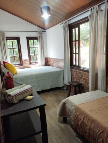 レゼンデにあるCanto da Pedra Visconde de Mauáのベッド2台とテーブルと窓のある寝室