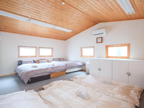 two beds in a room with wooden ceilings at Urayasu Horie House in Tokyo