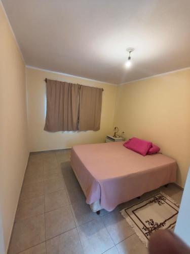 ein Schlafzimmer mit einem rosa Bett und einem Fenster in der Unterkunft Quique1 in Pilar