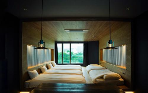 a room with a long couch with a window at SEKAI HOTEL Deep Osaka Experience in Osaka