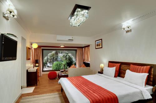 a hotel room with a bed and a large window at Chacha Inn The Garden Retreat in Mount Ābu