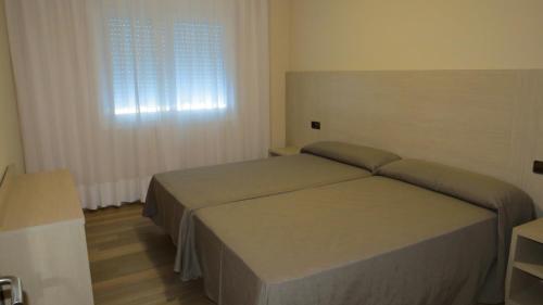 a bedroom with a bed and a window at Apartaments Players in Malgrat de Mar