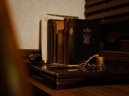a table with a book and a pair of glasses at Chronos House Tokyo Kitasenju - Time Travel Stay in Tokyo