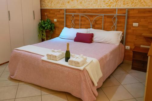 a bed with a bottle of wine and two towels at Bed and Breakfast La Primavera NOLA in Nola