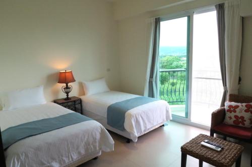 a hotel room with two beds and a window at Andalucia in Taitung City